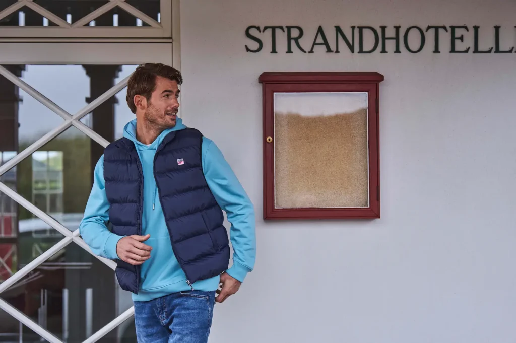 Hombre con sudadera azul claro y chaleco sin mangas azul marino VINSON