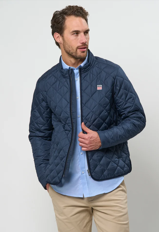 Chaqueta acolchada de rombos azul marino sobre camisa celeste y chino beige - Armario cápsula VINSON